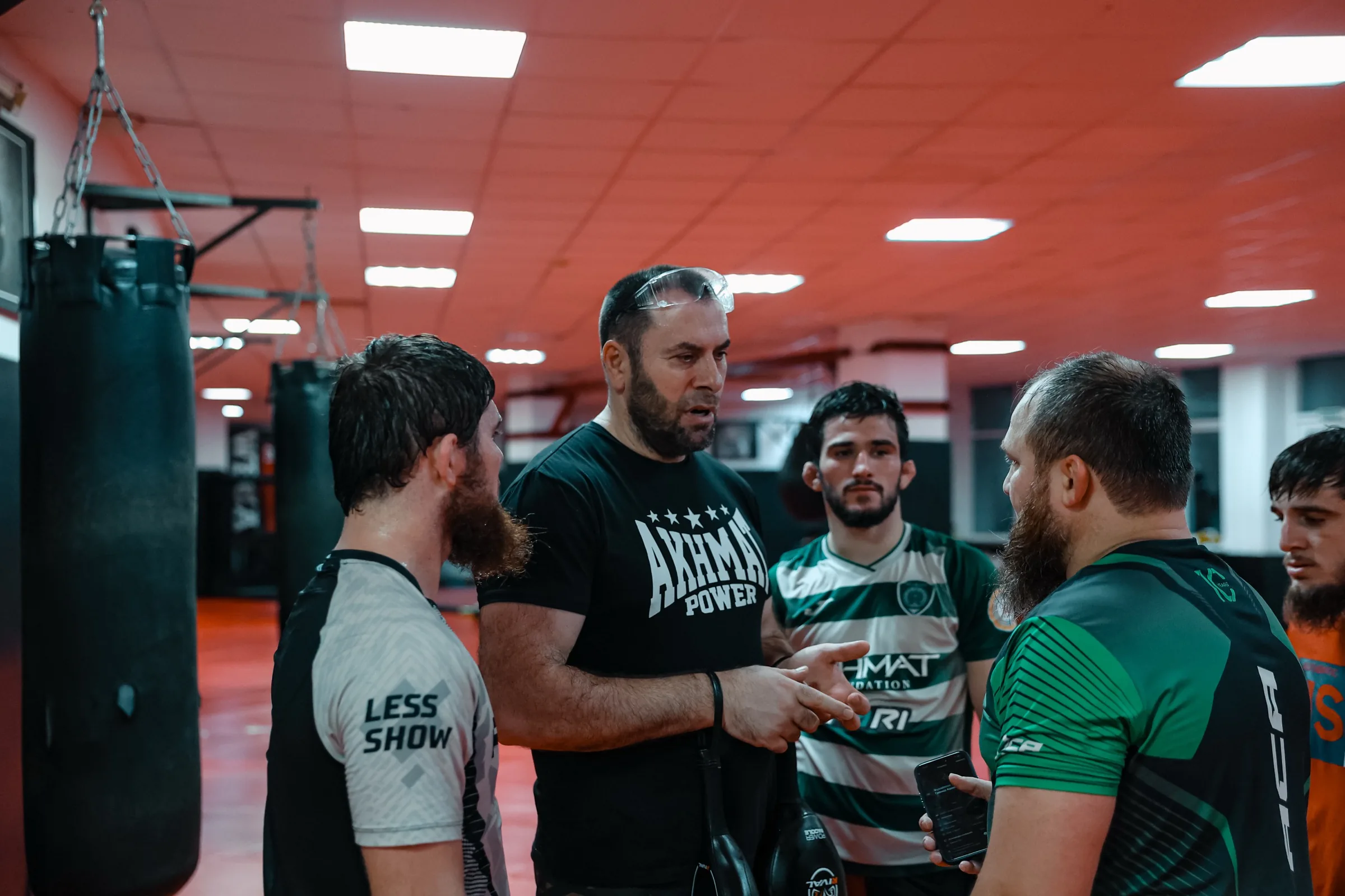 Coach de l'Akhmat Fight Club briefant quatre combattants dans la salle, à Grozny