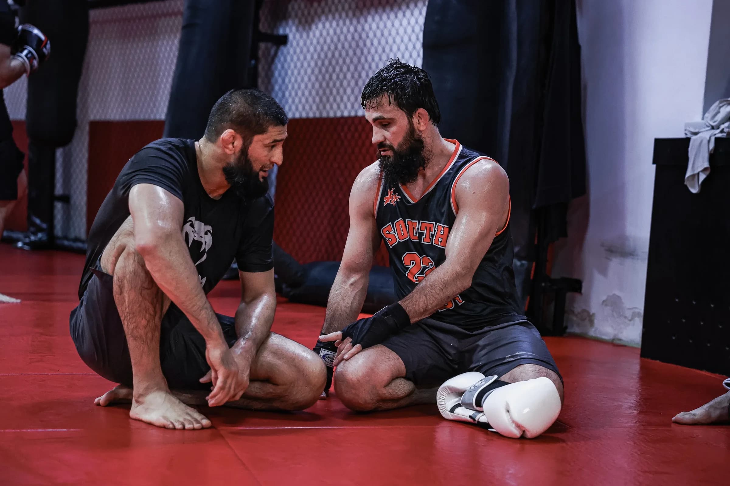 Coach taking care of an injured fighter at the edge of the mat