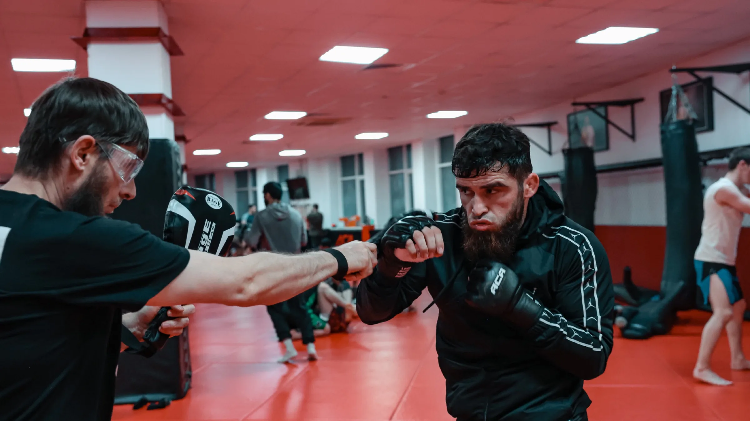 Group of five fighters gathered in the cage after the session