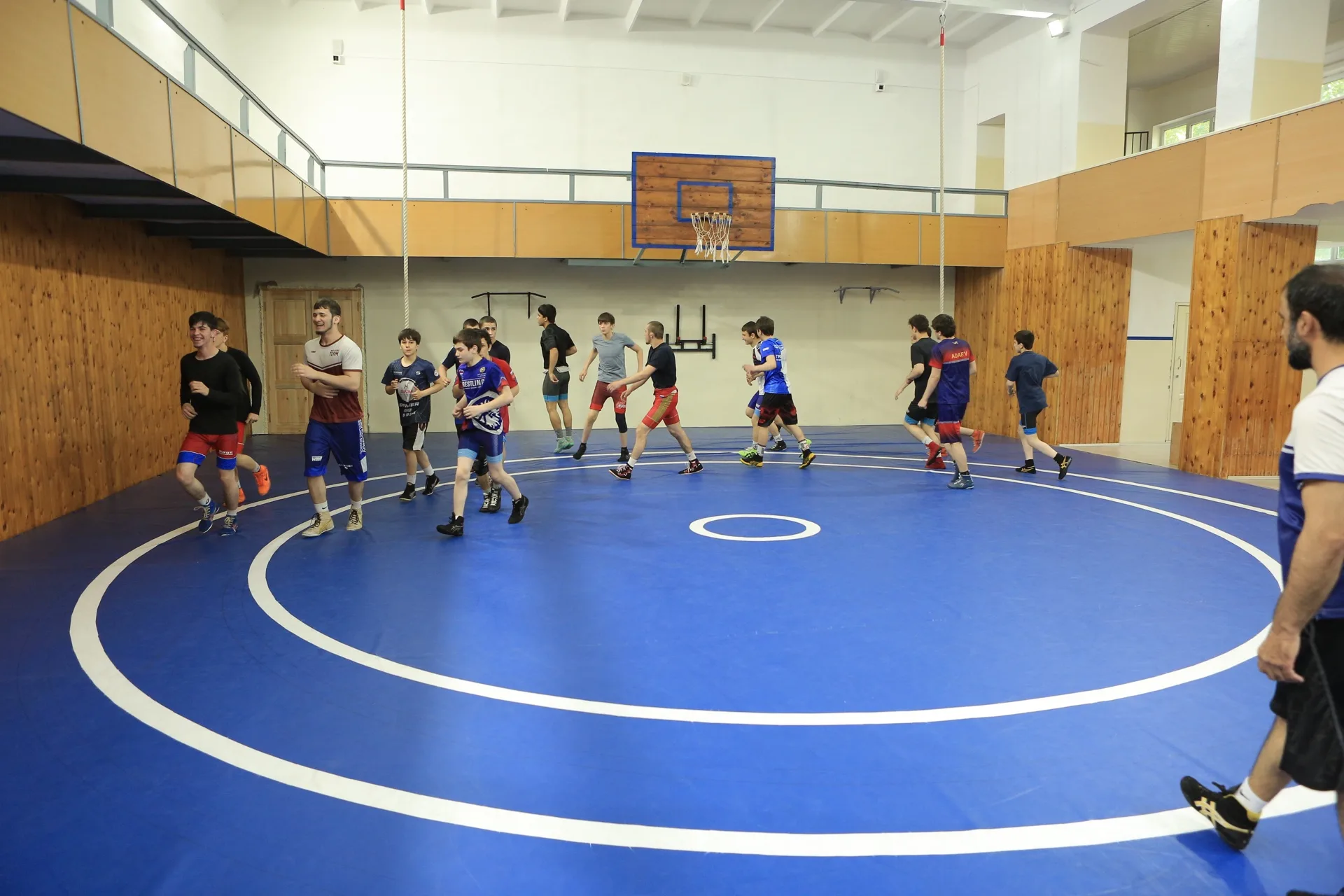 Wrestlers running on the mat during the warm-up, wrestling room in Dagestan