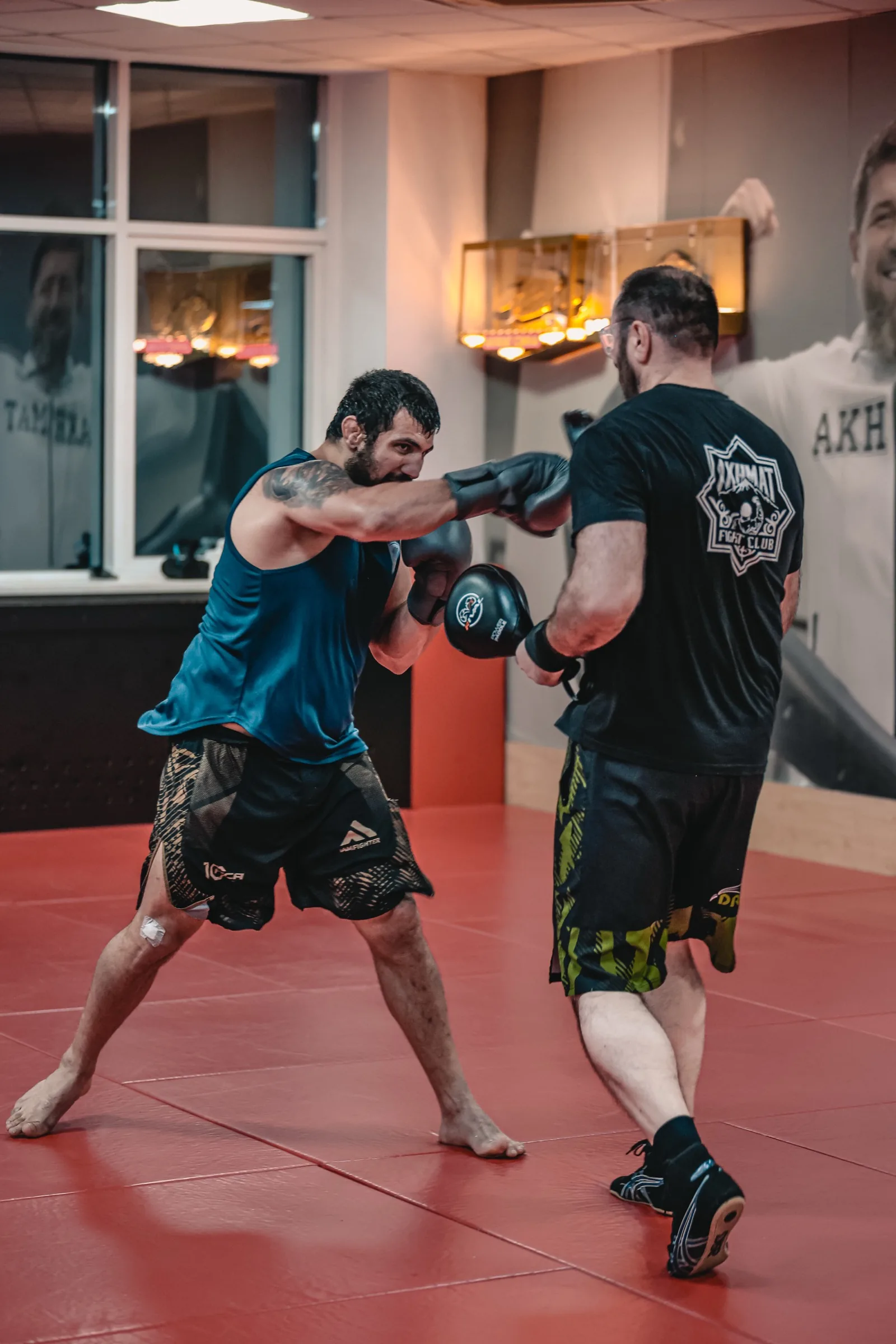 Sparring en cage, combattant turquoise vs coach noir