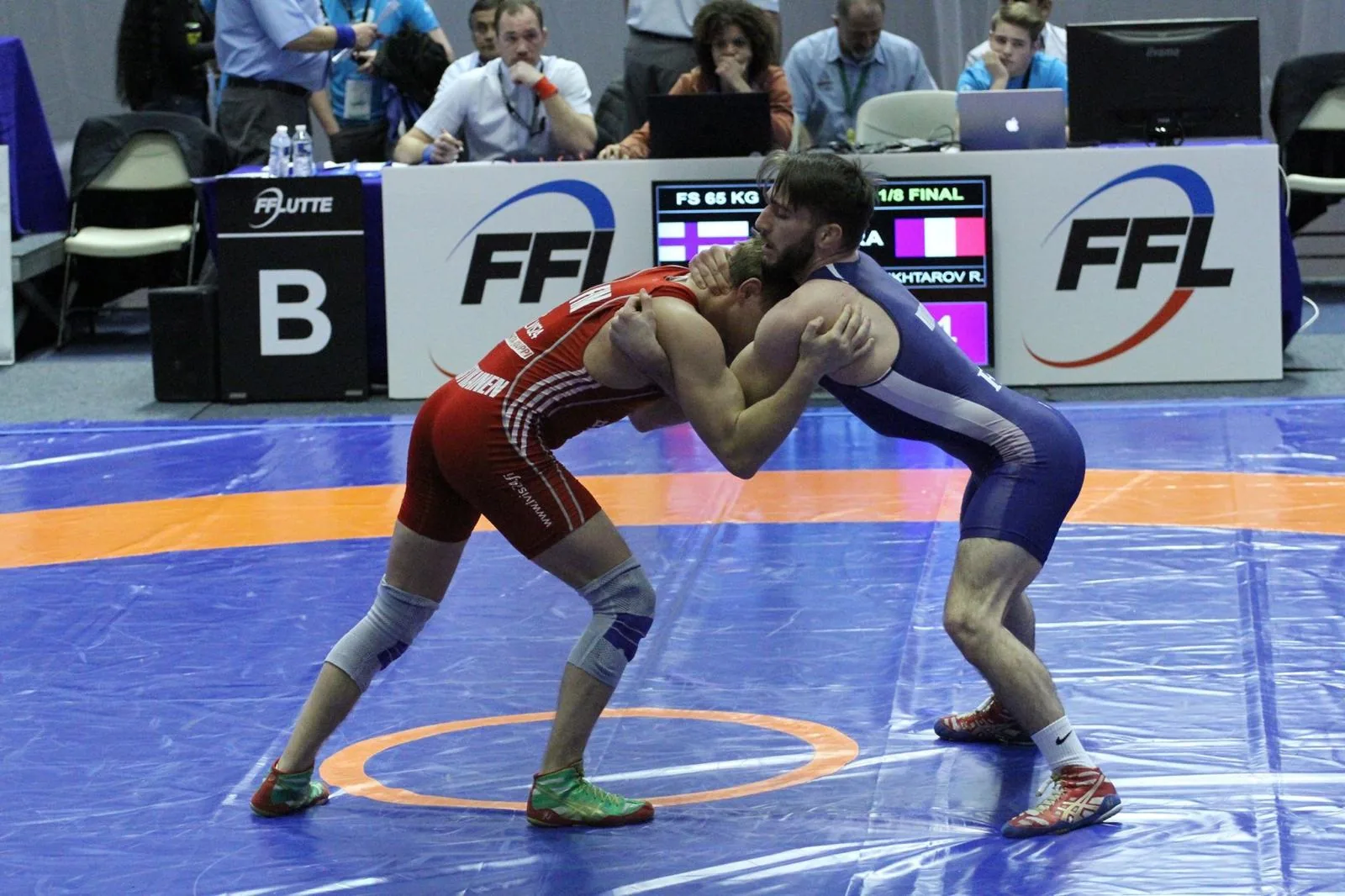 Ruslan Mukhtarov en singlet bleu équipe de France face à un adversaire en rouge, scoreboard FFL